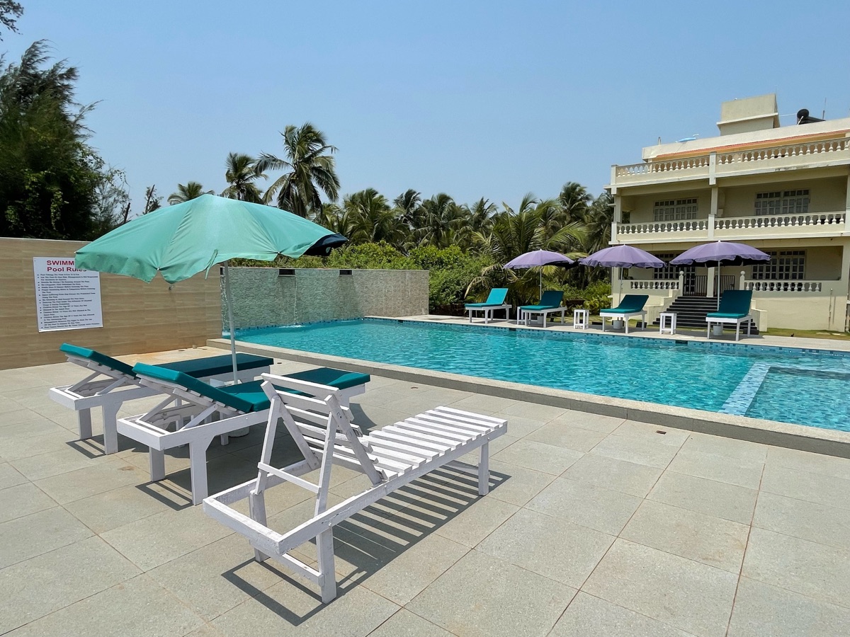 Serene view of Kay's By The Sea pool and Paradise Beach coastline